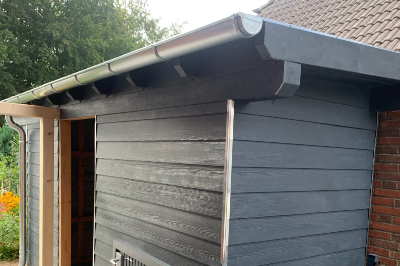 Fassade Dachkante eines Holzschuppens mit neuer Fassade grauer Farbe